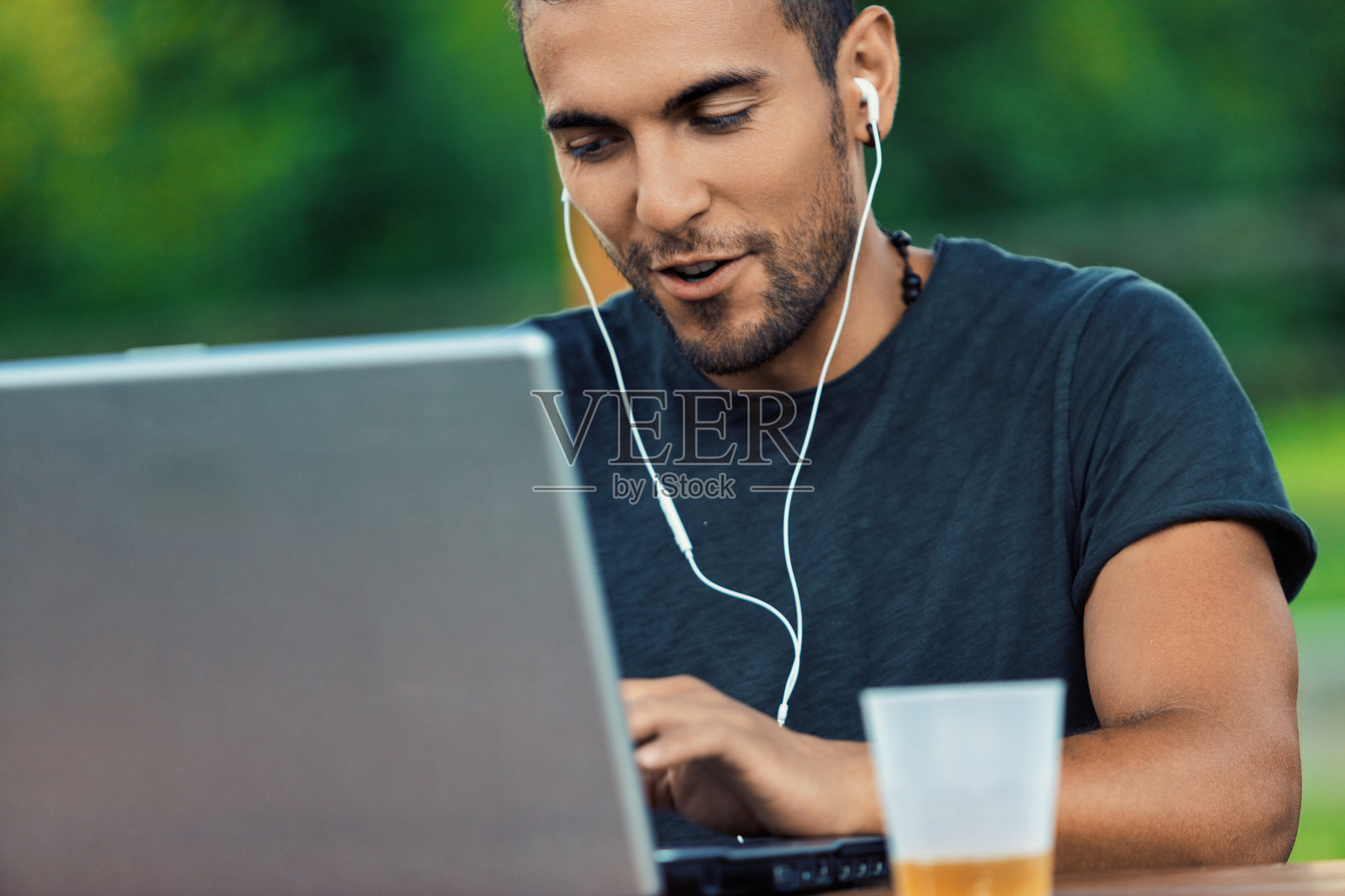 在户外喝着啤酒的自由职业者使用笔记本电脑远程工作照片摄影图片