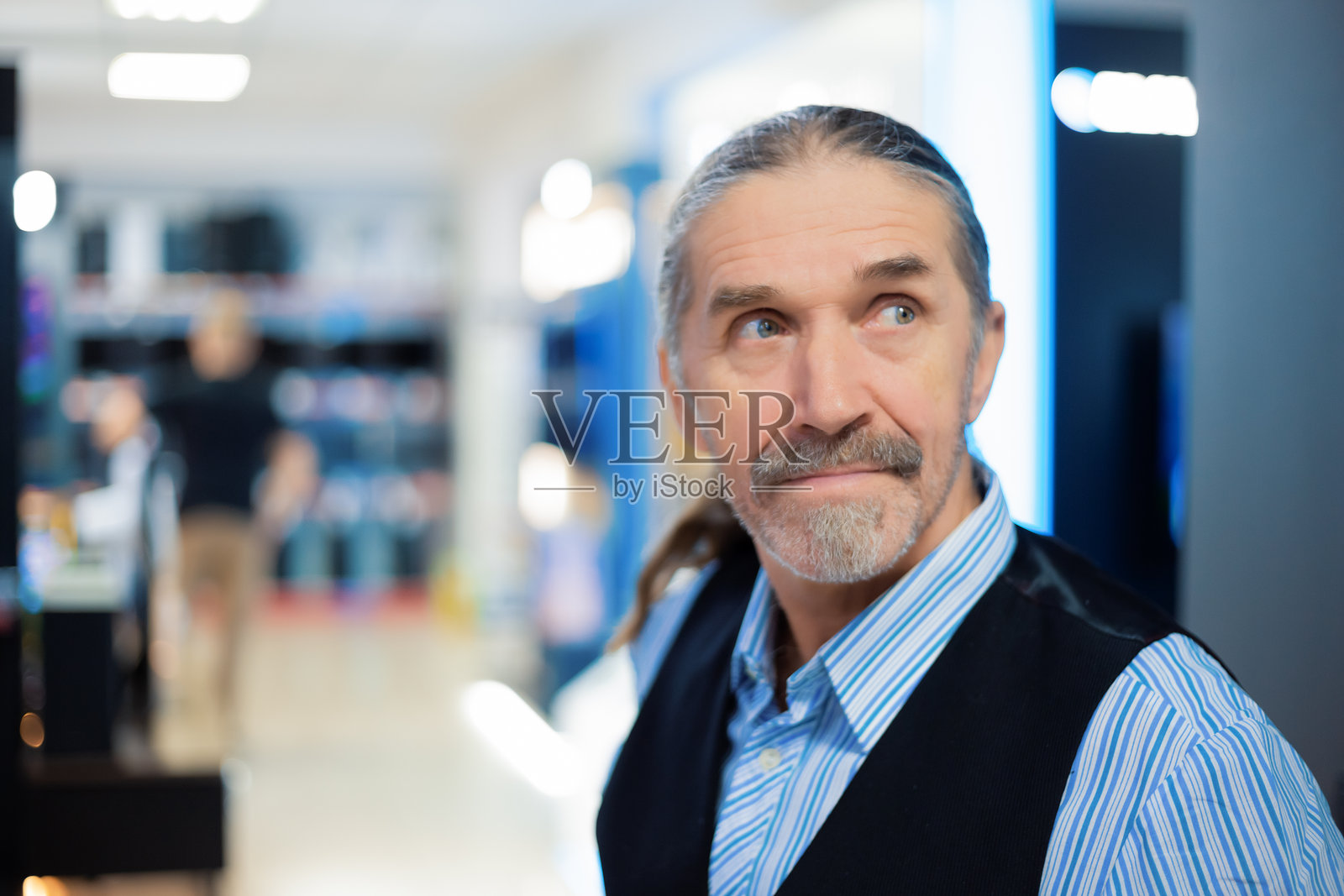 男子在电子商店里好奇地浏览商品照片摄影图片