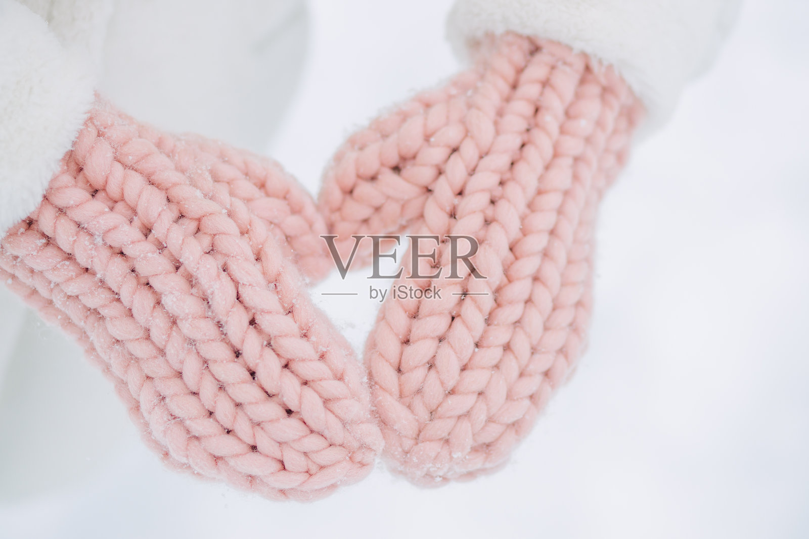 冬季城市公园中，穿着粉色手套的女性特写。照片摄影图片