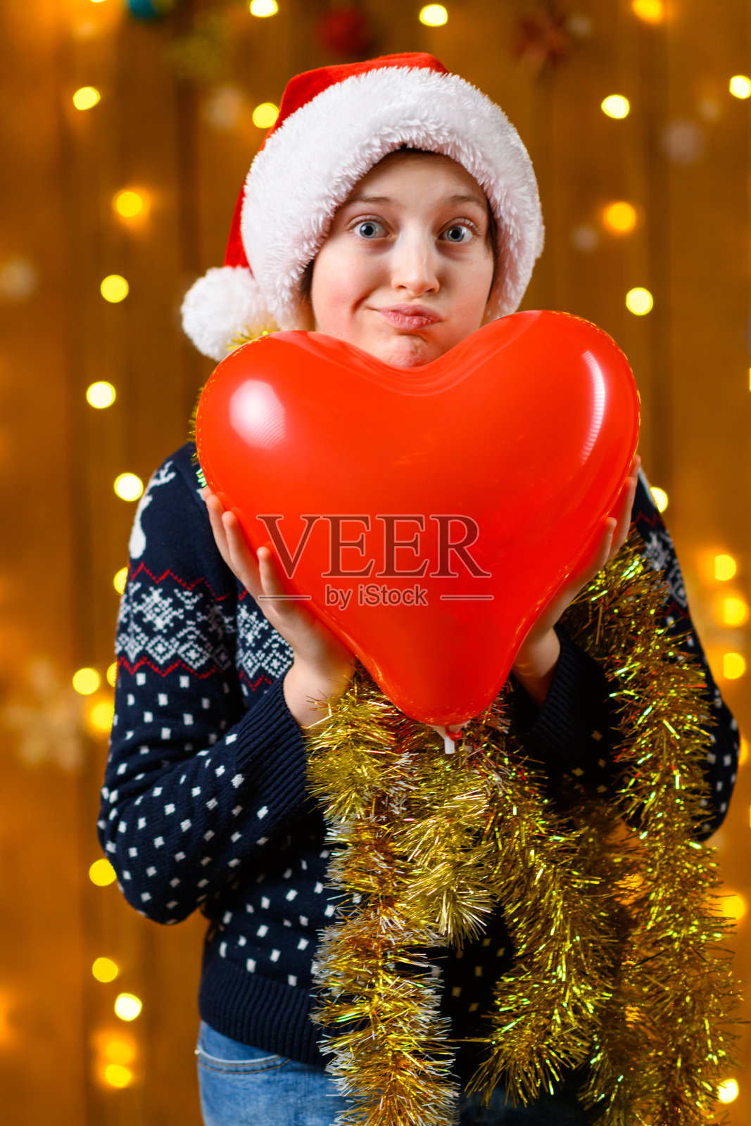 一名少女在新年装饰下摆姿势，周围有节日的灯光和花环、圣诞灯饰和装饰，节日主题。照片摄影图片