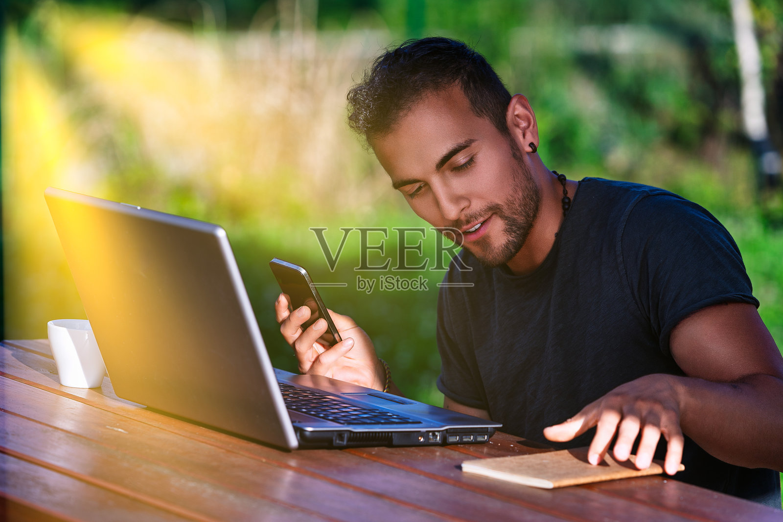 年轻的自由职业者在家中使用笔记本电脑和智能手机远程工作照片摄影图片