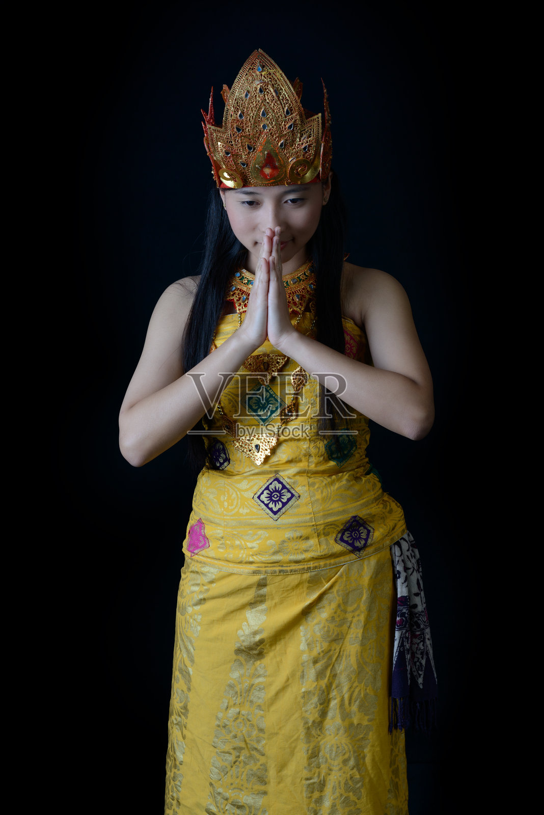 身穿传统服饰的印尼女性做出合十礼姿势照片摄影图片