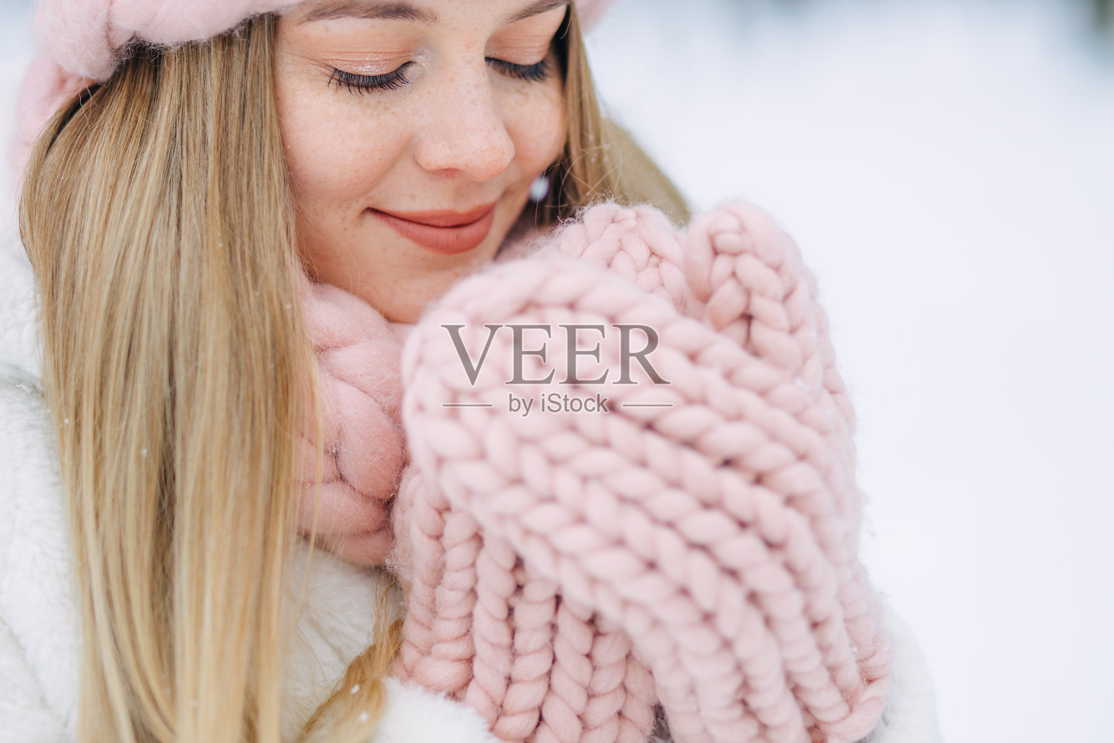 年轻微笑的快乐女性在冬季户外，雪林中的特写肖像照片摄影图片