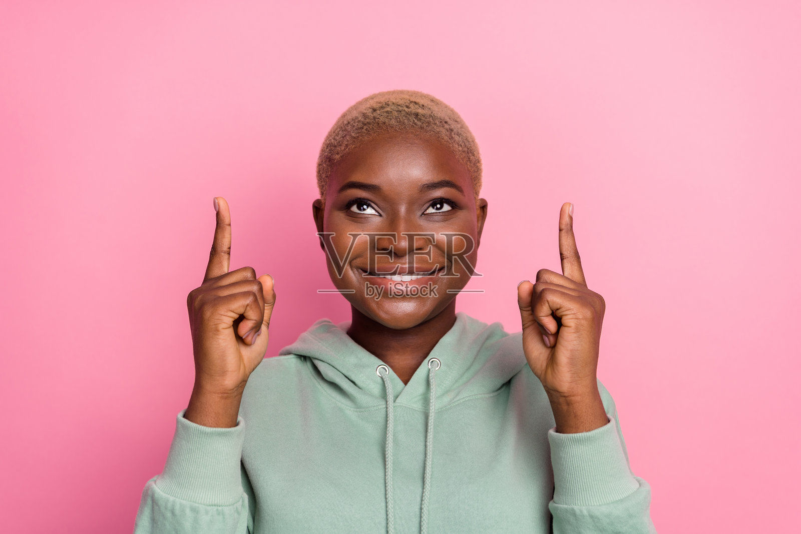 年轻漂亮的女性在粉色背景上看到黑色星期五促销广告，宣传购物特卖。照片摄影图片