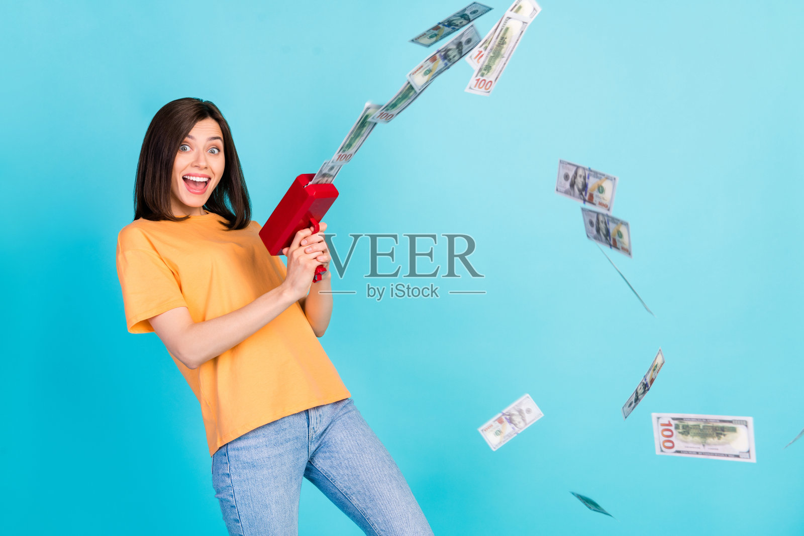 一位快乐的漂亮女士穿着时尚的衣服，庆祝拥有大量财富，享受奢华生活，背景为蓝色的空旷空间。照片摄影图片