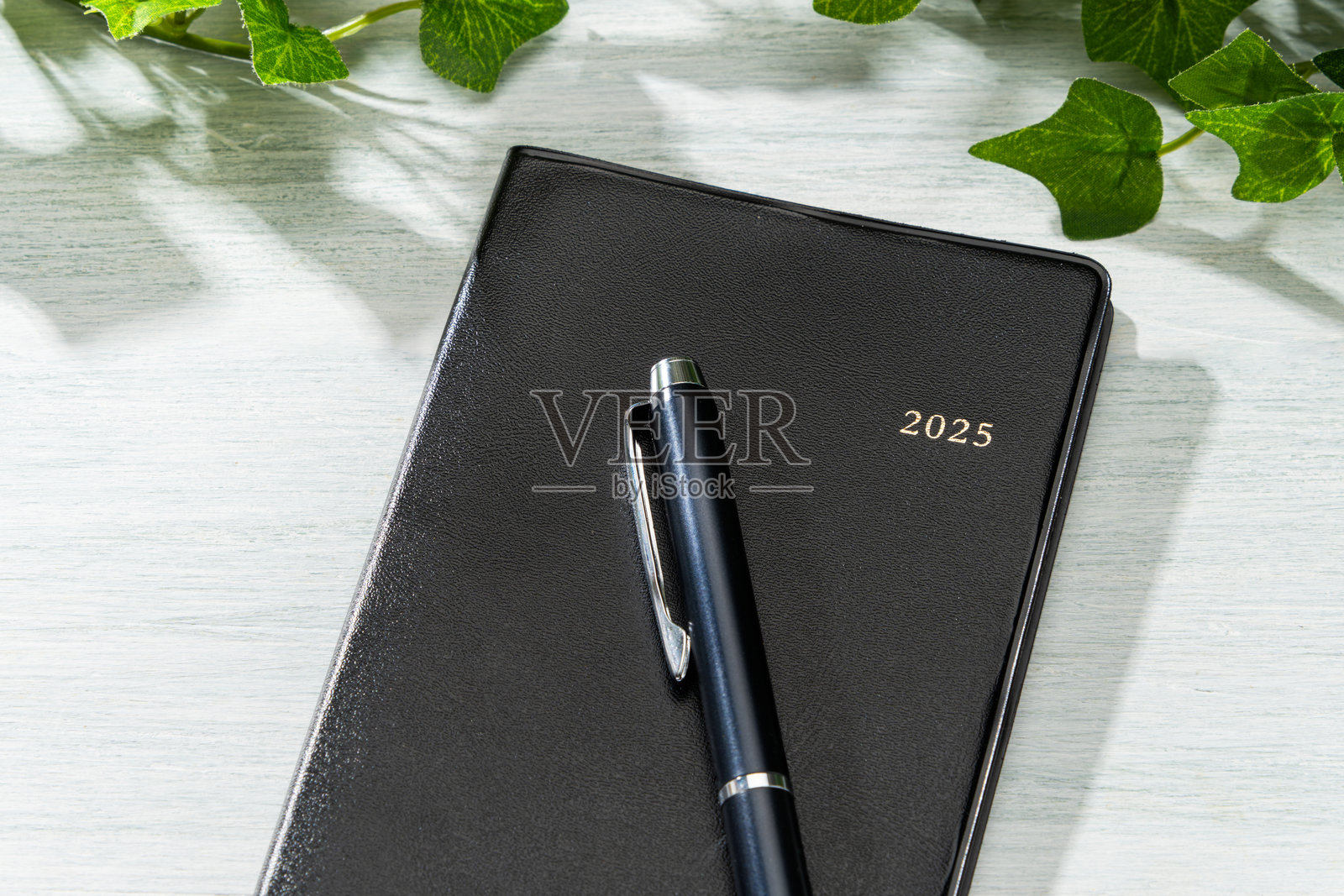 2025年笔记本和钢笔放在木桌上（2025年日程本）照片摄影图片