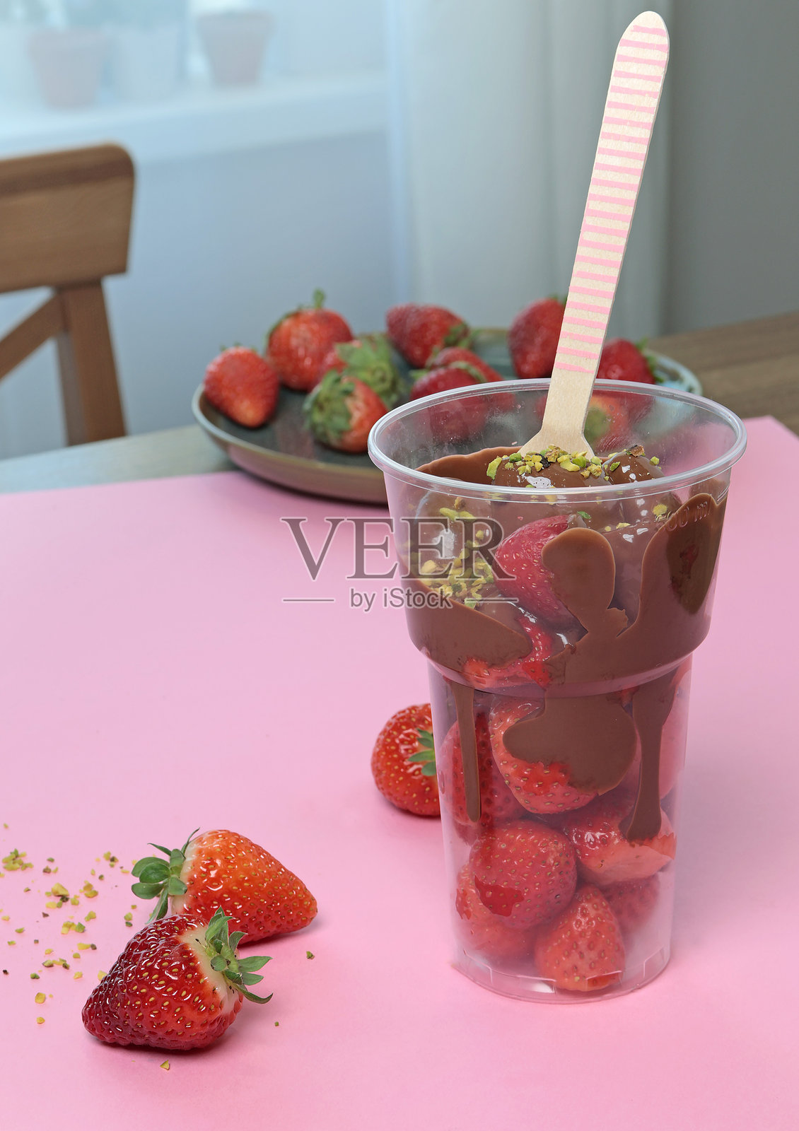 整杯新鲜草莓浸泡在融化的液态巧克力中。照片摄影图片