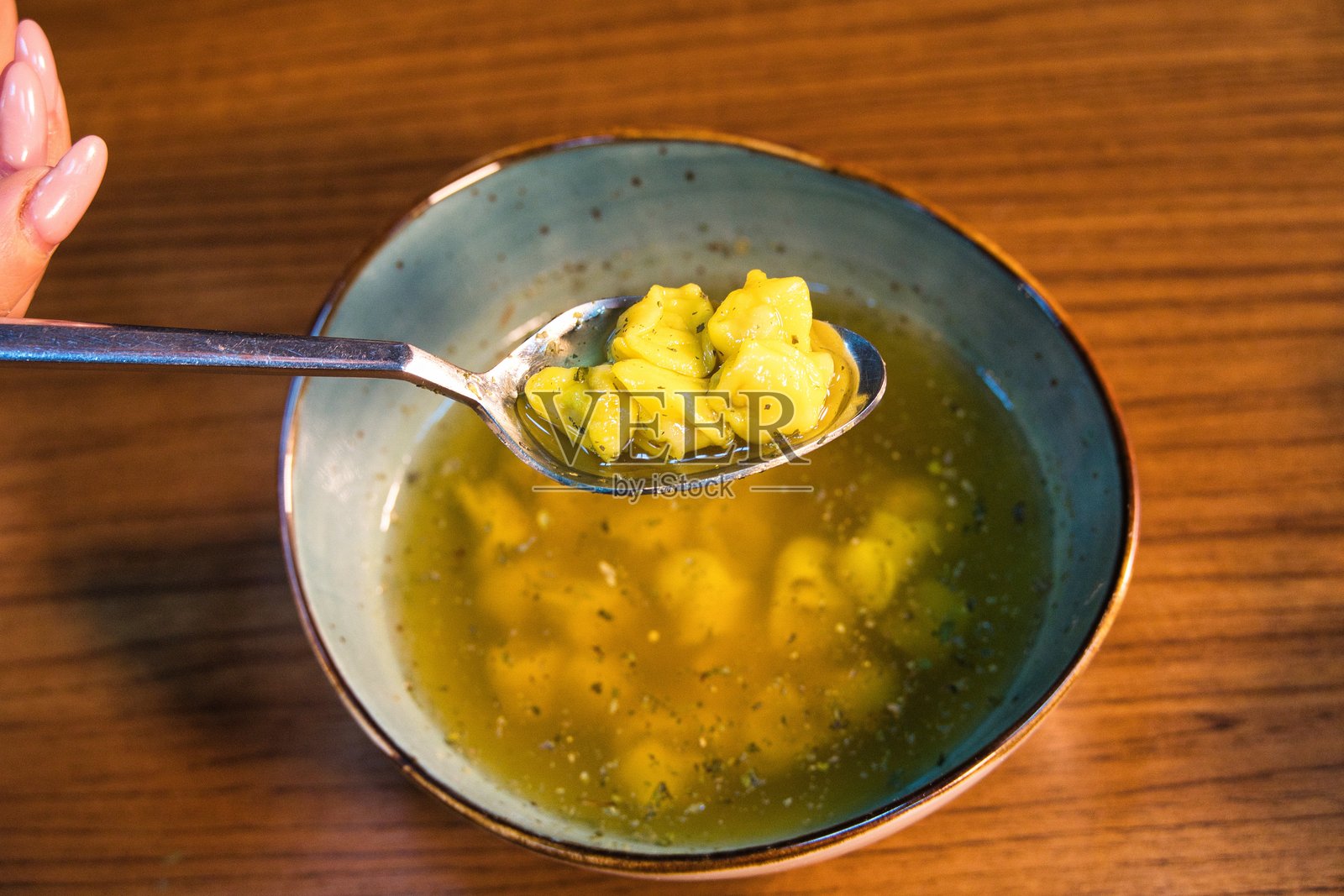 桌子上的一勺意大利面汤照片摄影图片