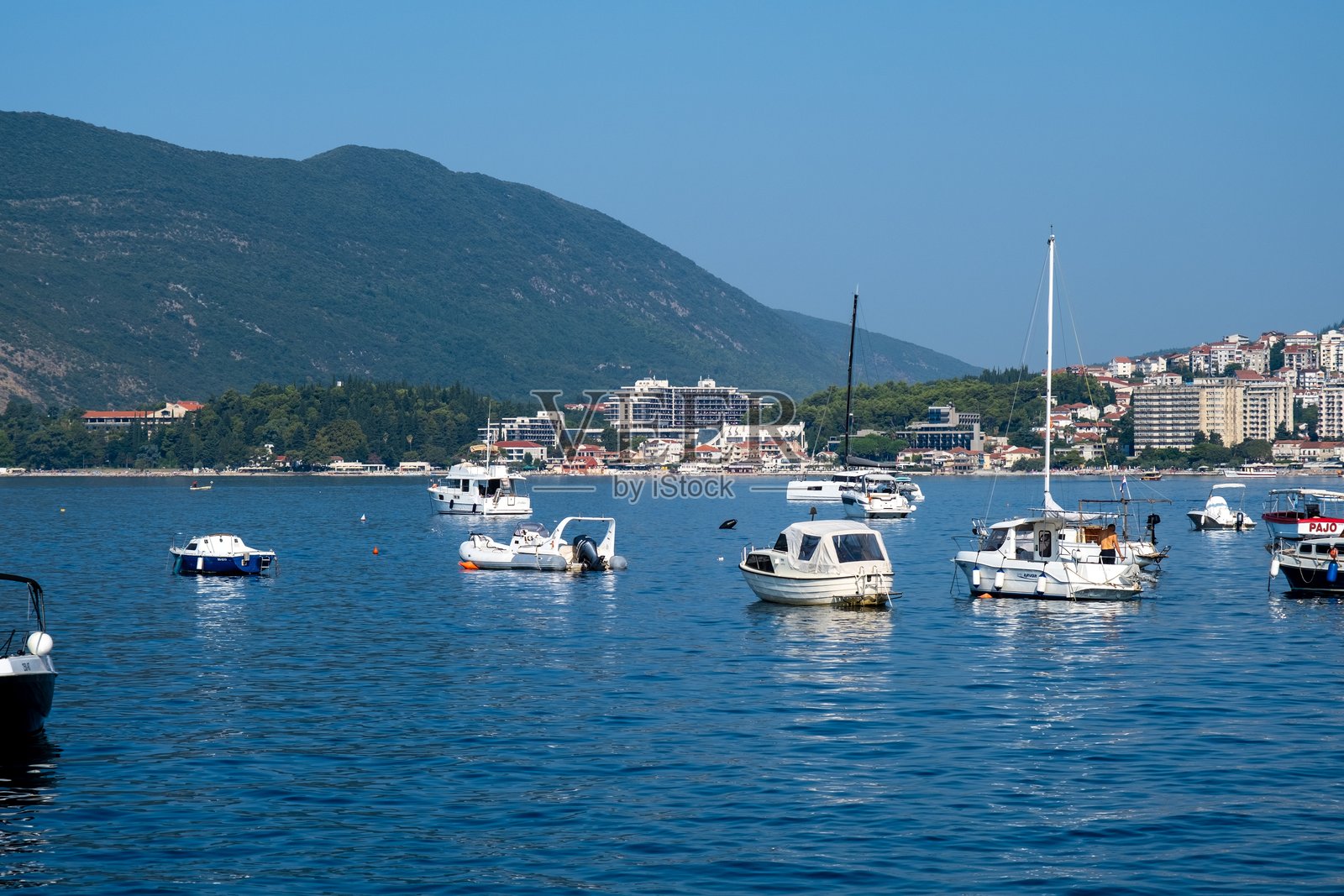 停靠在海湾的船只与山景照片摄影图片