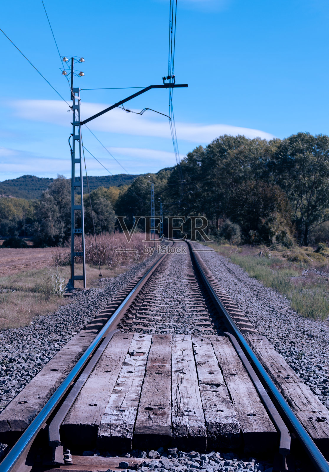 阳光明媚的秋日铁路。竖拍。照片摄影图片
