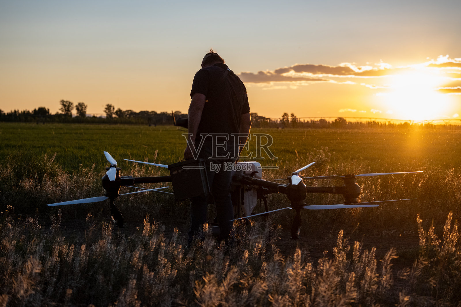 操作员正在更换农业无人机的电池。照片摄影图片