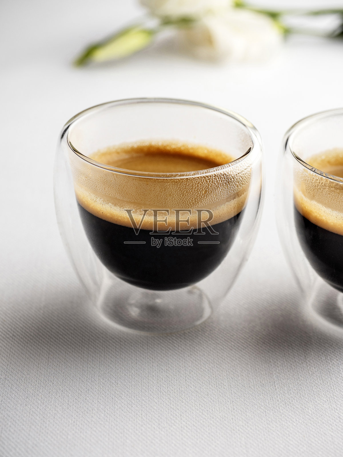 浓缩咖啡。装有浓缩咖啡的杯子。新鲜冲泡的奶油浓缩咖啡在玻璃咖啡杯中。浓缩咖啡杯。照片摄影图片