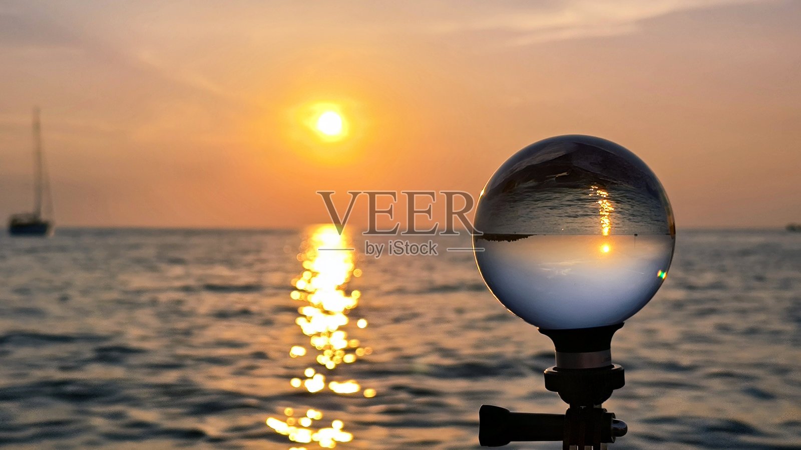 在波雷奇的亚得里亚海边，透过玻璃镜球看到的日落照片摄影图片