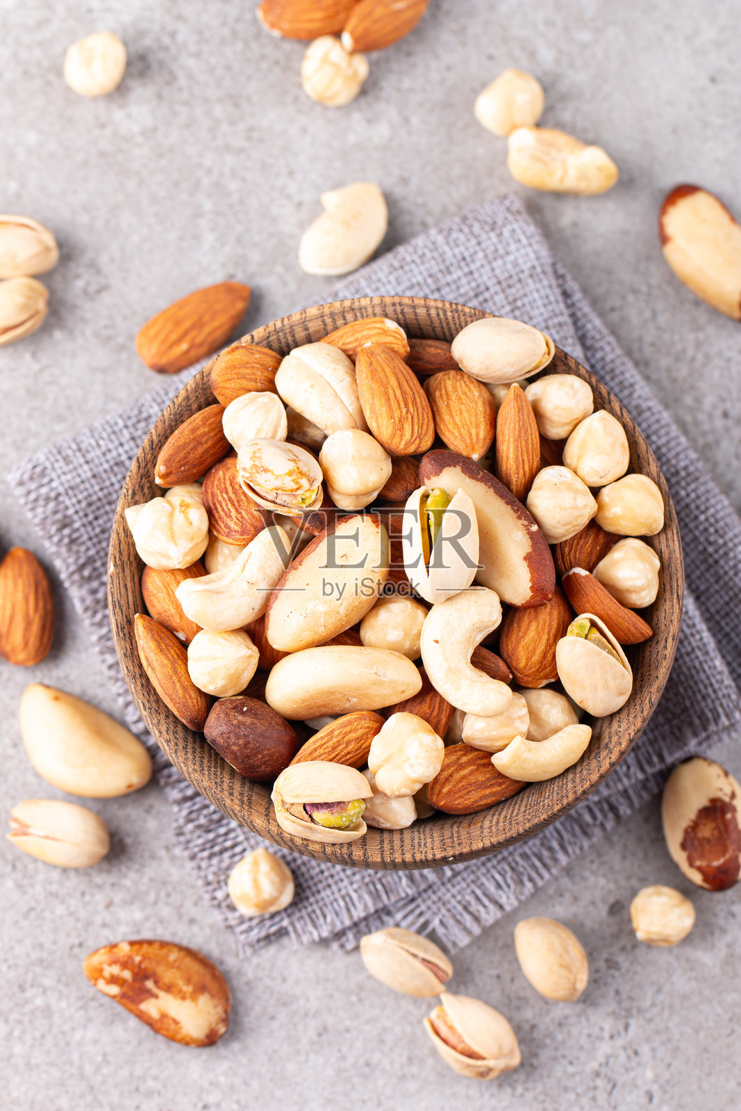 健康混合坚果在木质背景上。杏仁、榛子、腰果、花生、开心果、巴西坚果照片摄影图片