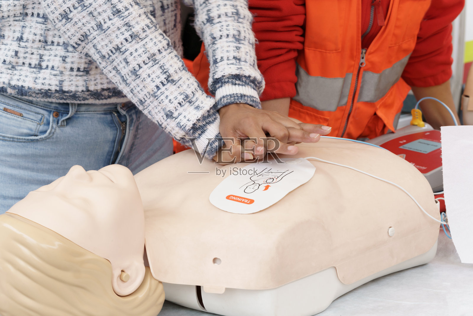 教练使用假人和自动体外除颤器进行心肺复苏培训照片摄影图片