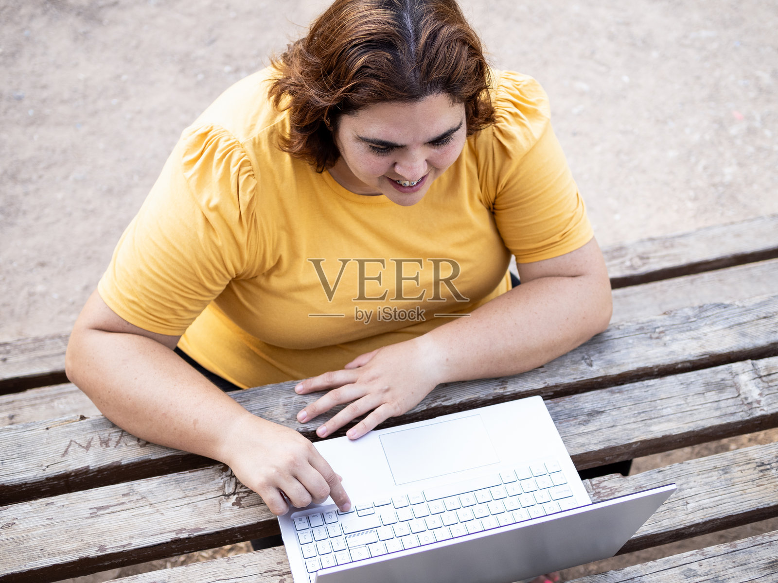 一位智力障碍女性在户外查看她笔记本电脑上的图片照片摄影图片