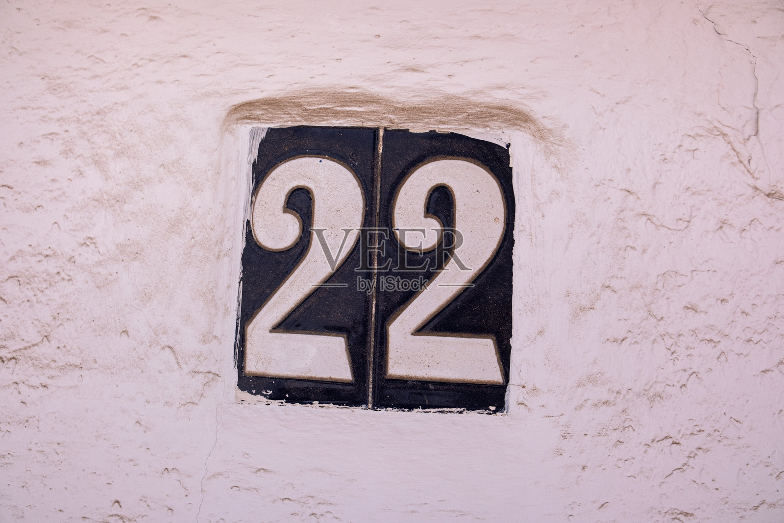 西班牙风格的美丽房屋号码22。房屋号码位于西班牙老城的陶瓷图案底座上。传统西班牙图案装饰的盘子，上面有公寓或房屋号码。照片摄影图片