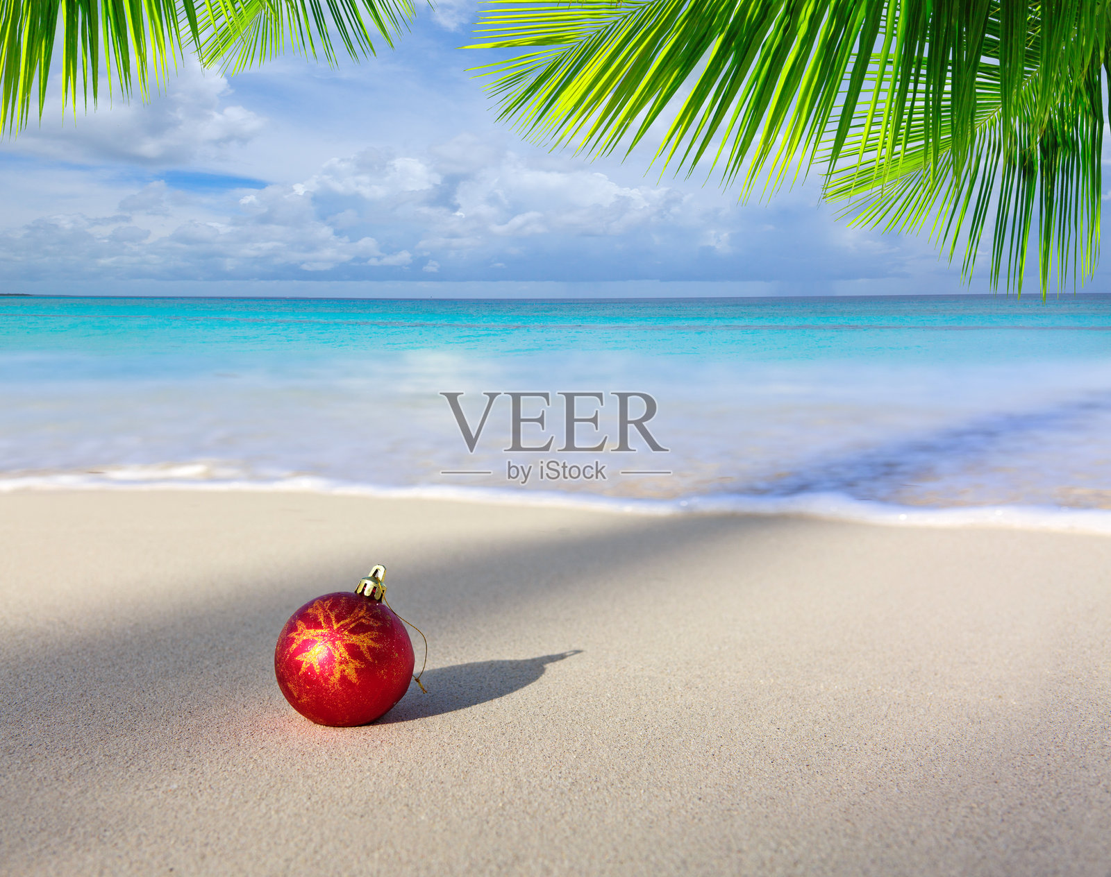 加勒比海滩上的圣诞快乐背景，红色球饰。照片摄影图片