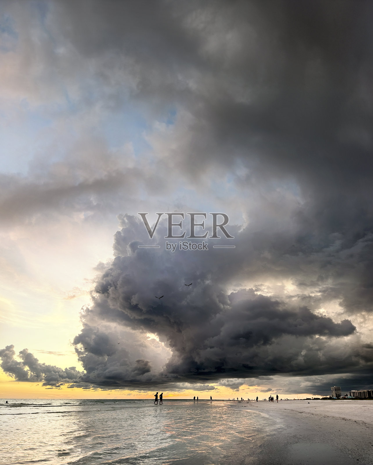 人们在美丽的日落时分享受热带沙滩。照片摄影图片