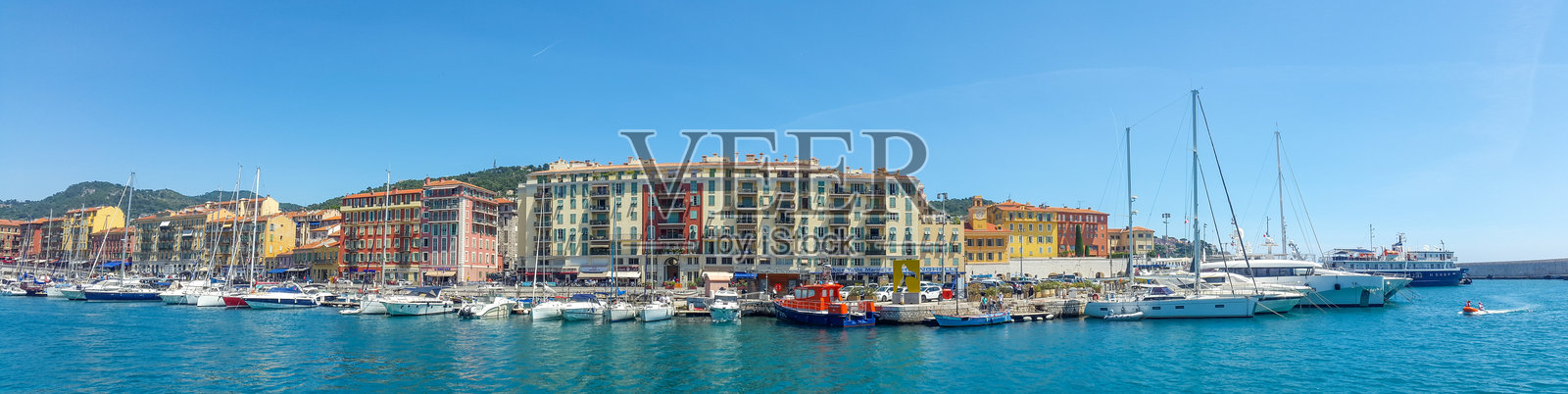 一个有许多船只在水中停靠的港口，背景是一座城市。照片摄影图片