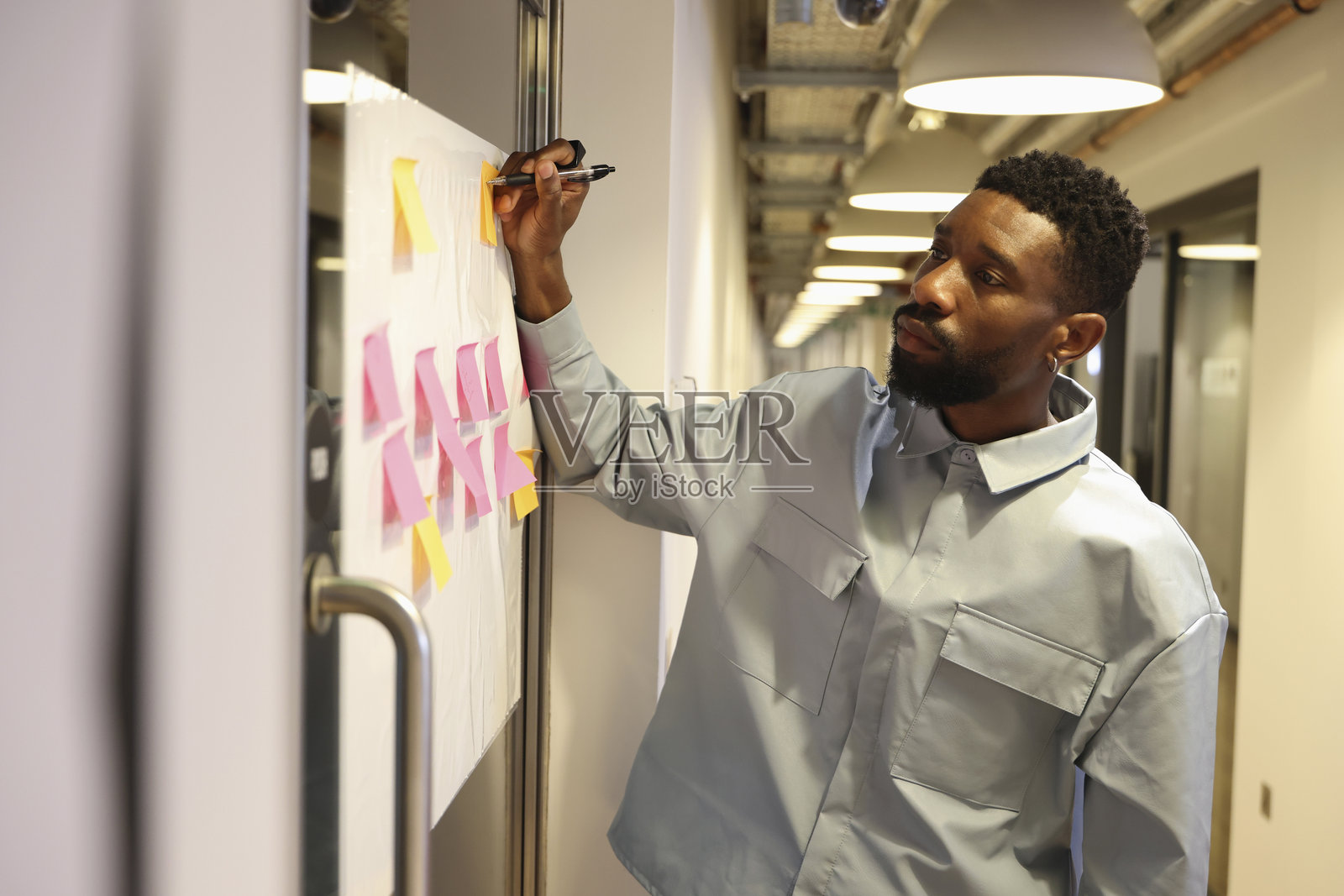 员工在公告栏上做笔记照片摄影图片