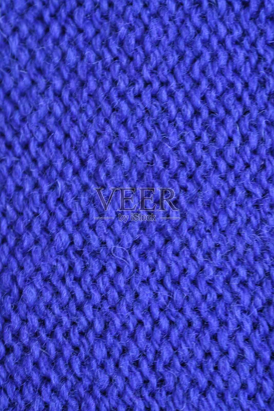 紫色毛线钩织毛衣的宏观纹理作为背景，紫色钩织前表面的特写，毛线的纹理，钩织前表面照片摄影图片
