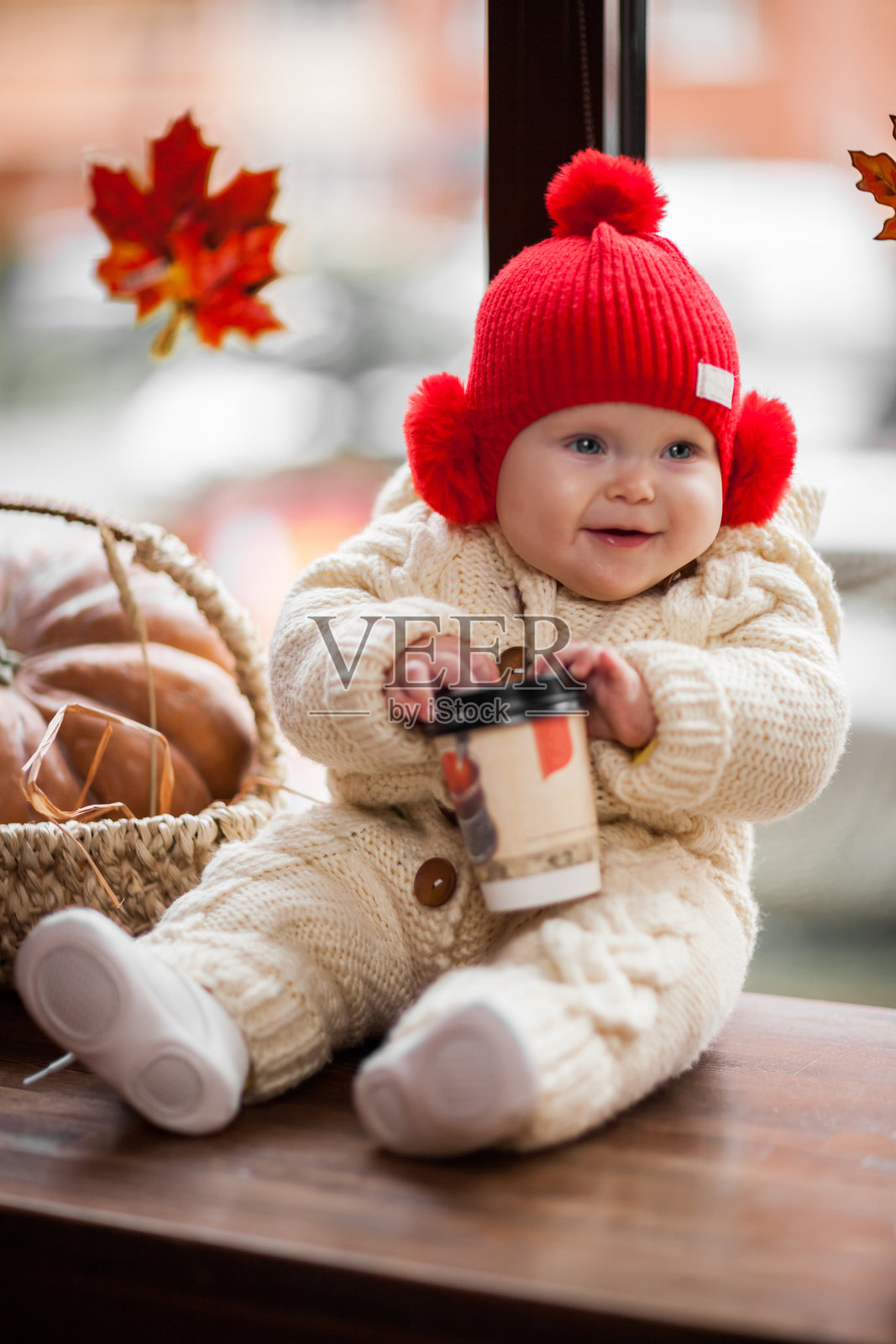 微笑的女孩在桌子上玩一次性杯子照片摄影图片