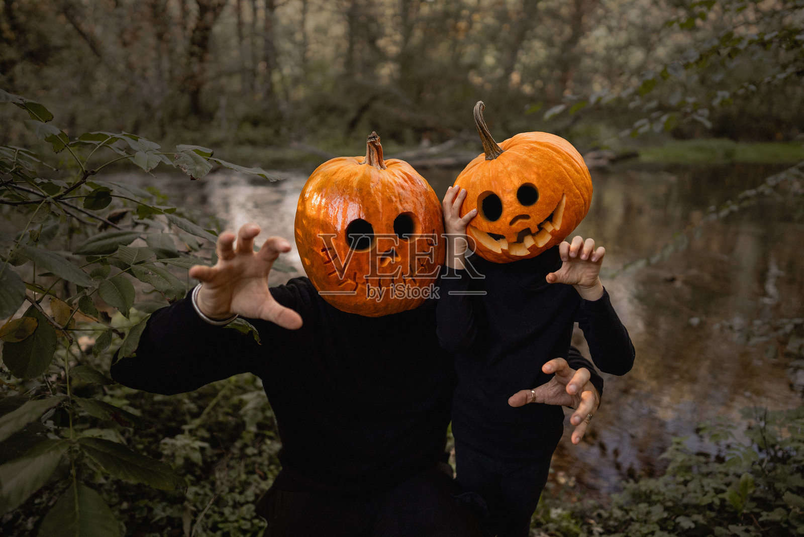 可怕的小男孩和他的父亲，头戴南瓜头，万圣节。杰克南瓜灯服装。不给糖就捣蛋，家庭吓唬你，玩恐怖故事。照片摄影图片