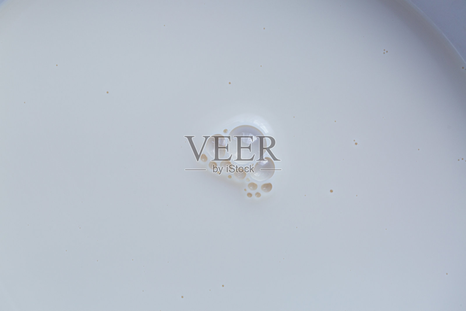 牛奶杯中牛奶泡沫的特写微距，豆浆背景的微距，豆浆质地的微距，白色豆浆泡沫在杯子顶部的特写，适合食品和饮料背景。照片摄影图片