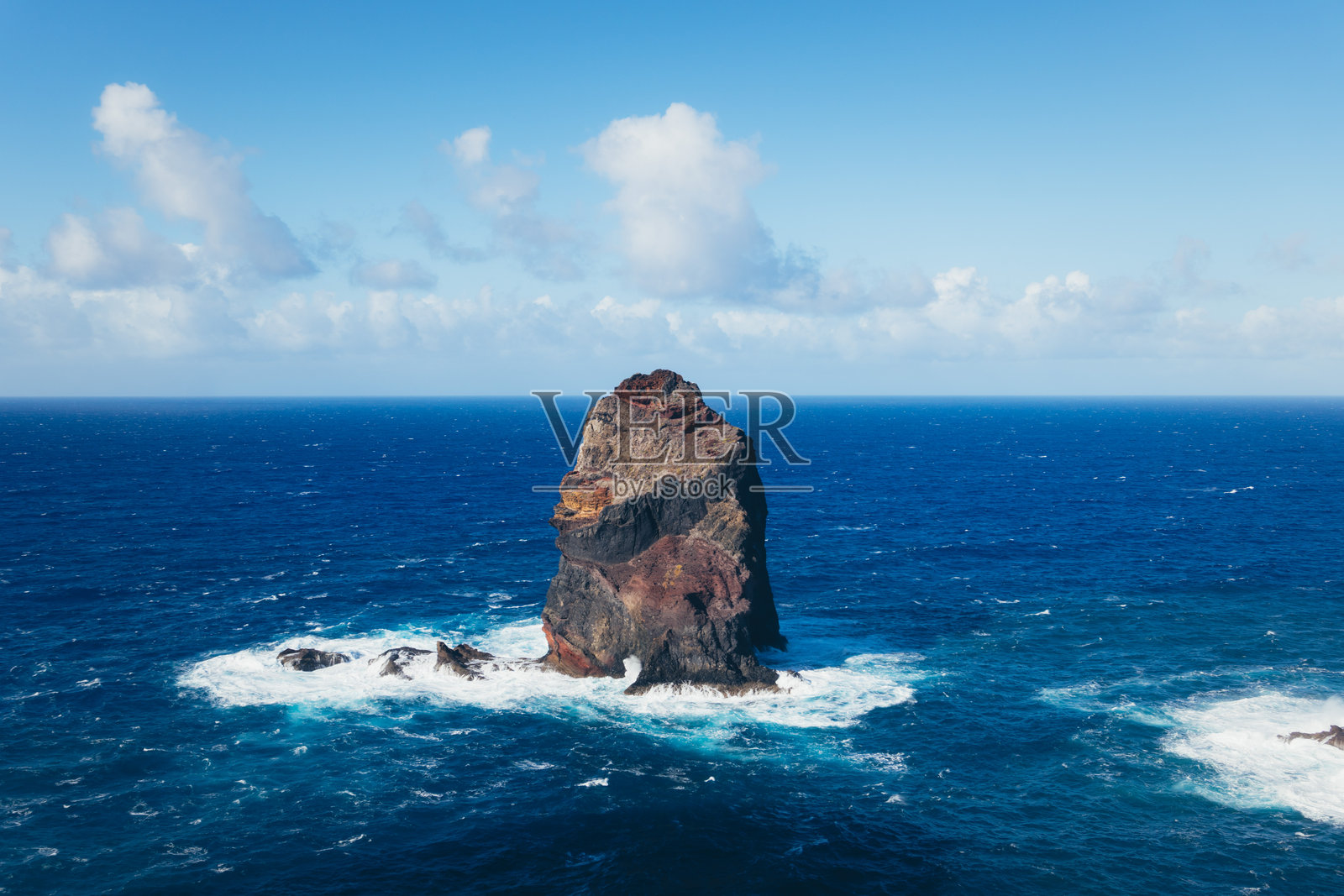 孤独的岩石岛屿在蓝色海洋中照片摄影图片