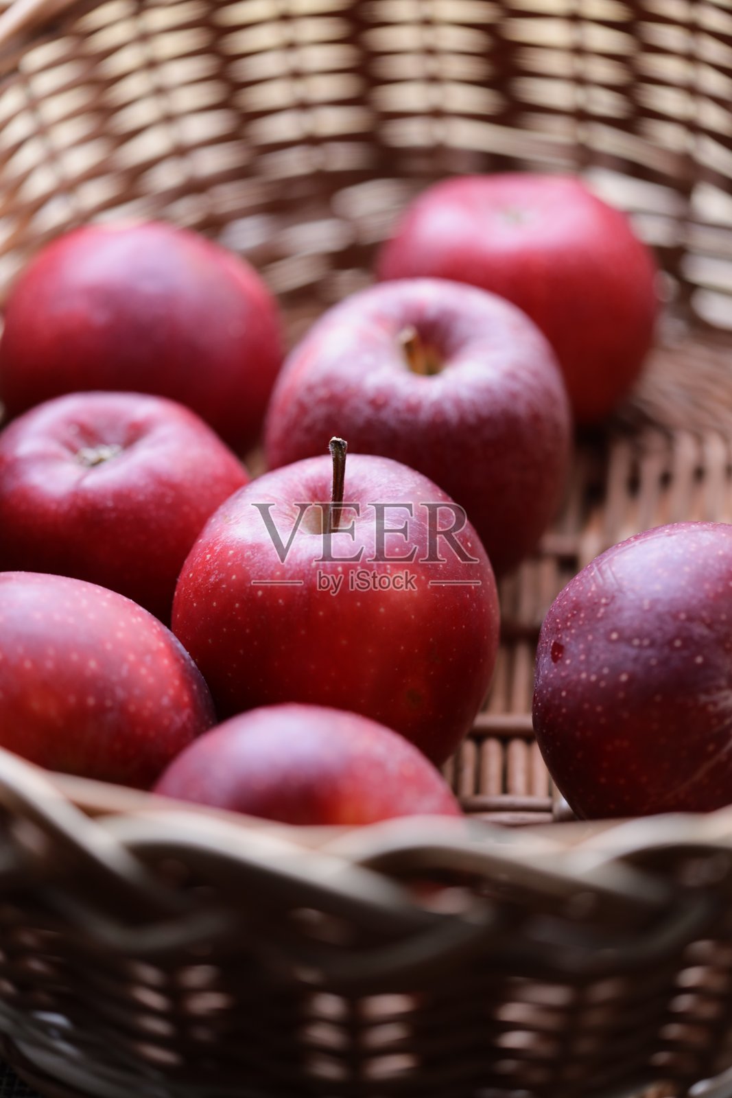 新鲜的红苹果放在编织的柳条篮子里，适合静物摄影或作为食品和饮品场景的道具照片摄影图片