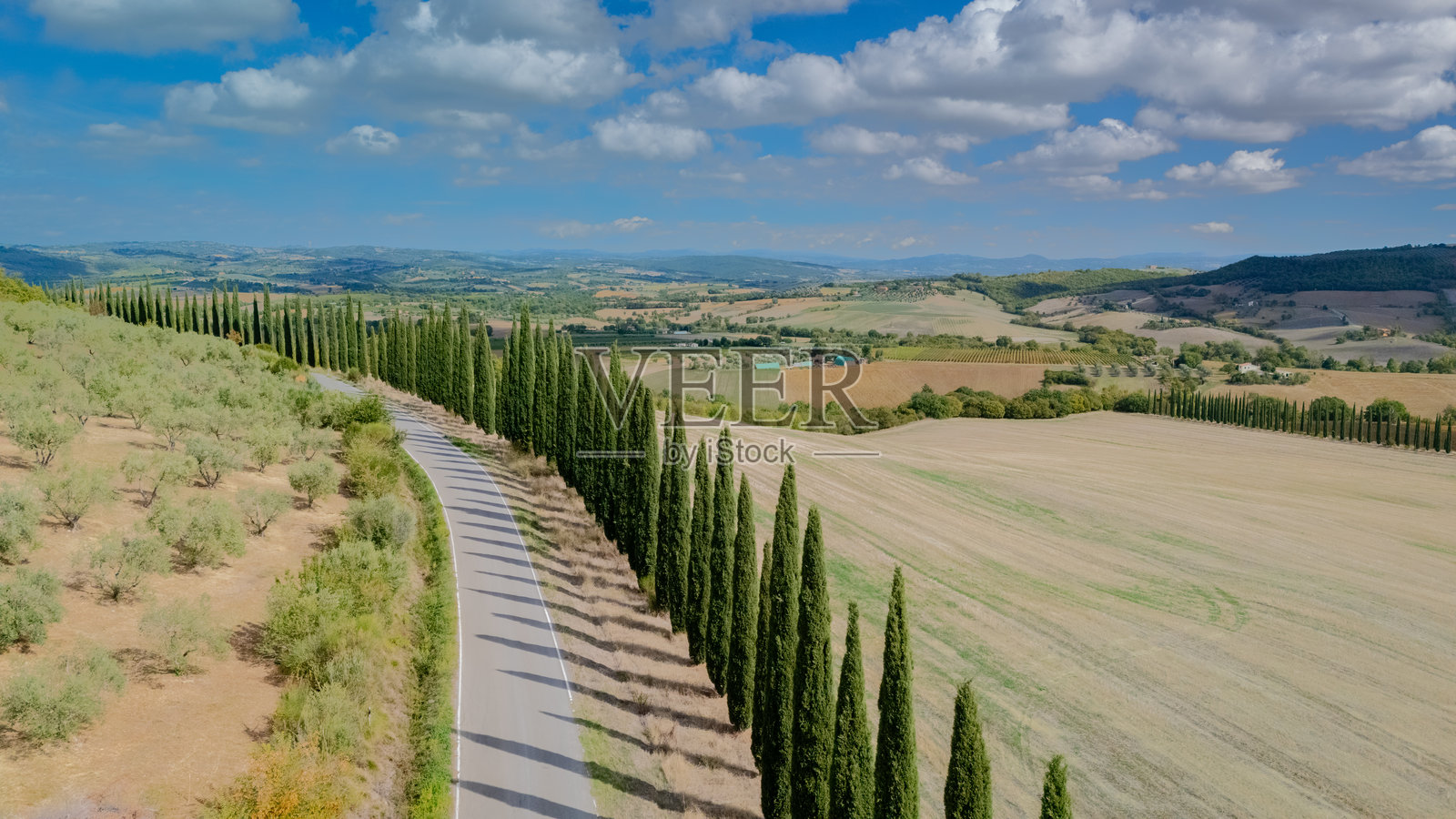 探索意大利托斯卡纳风景如画的山丘上蜿蜒的迷人柏树大道照片摄影图片