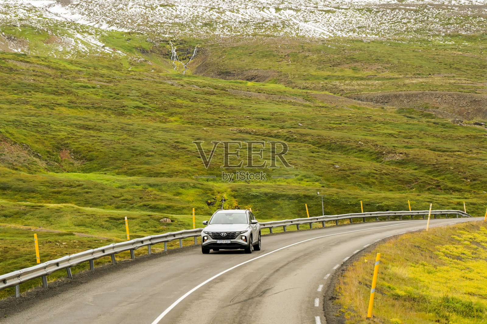 在冰岛北部的蜿蜒道路上行驶的汽车。照片摄影图片