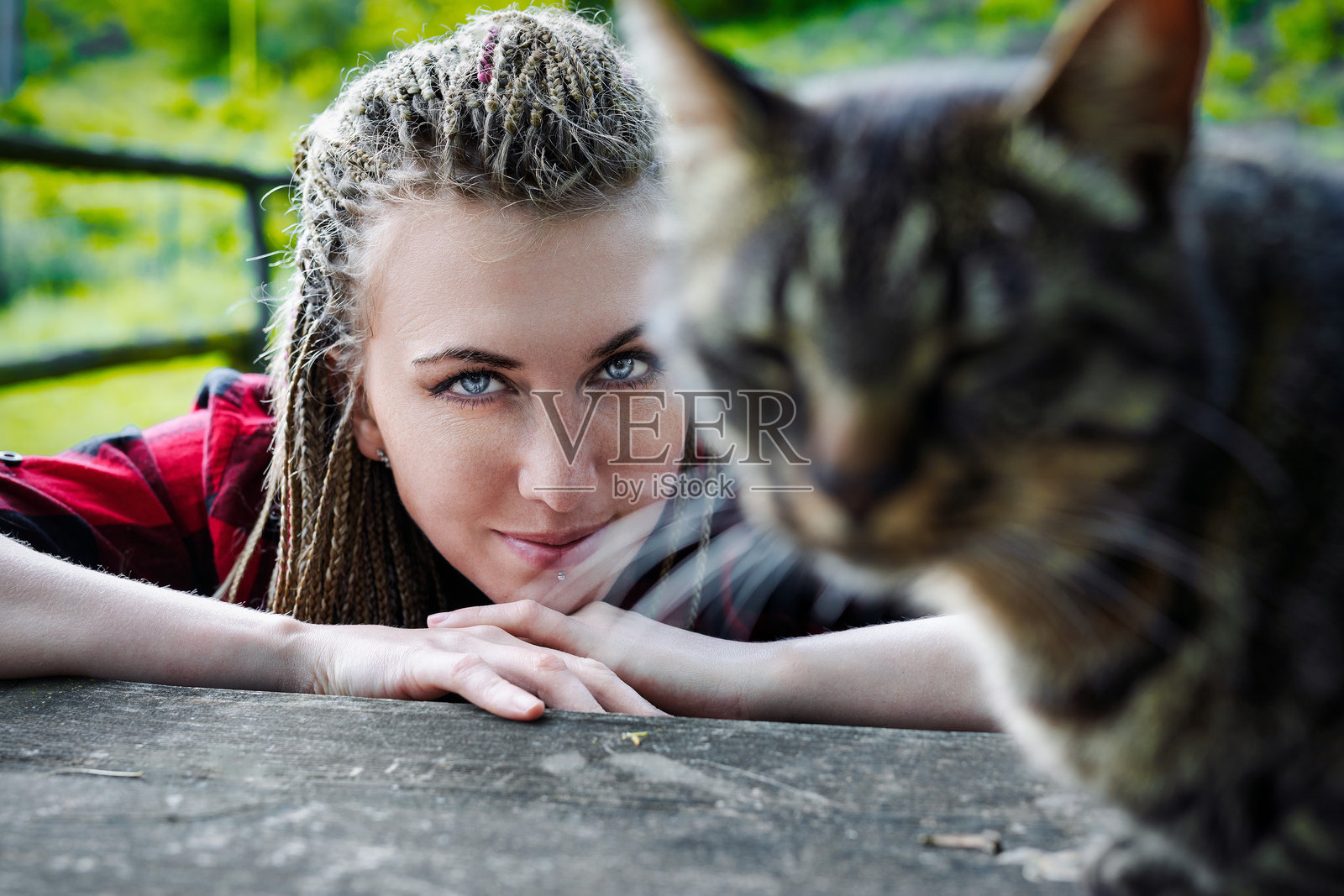 农民在农场院子里看着趴在木桌上的猫照片摄影图片