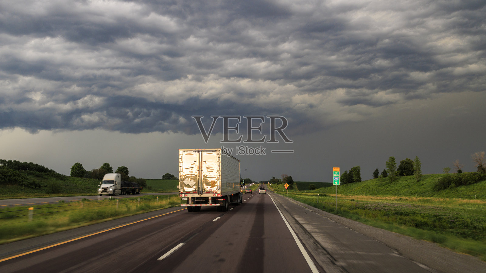 驶入暴风雨中。皮卡车和轿车在阴云密布的天空下行驶。照片摄影图片