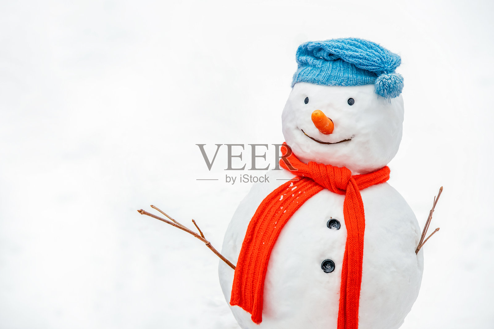 戴着针织帽和红色围巾的雪人，背景为白色。照片摄影图片