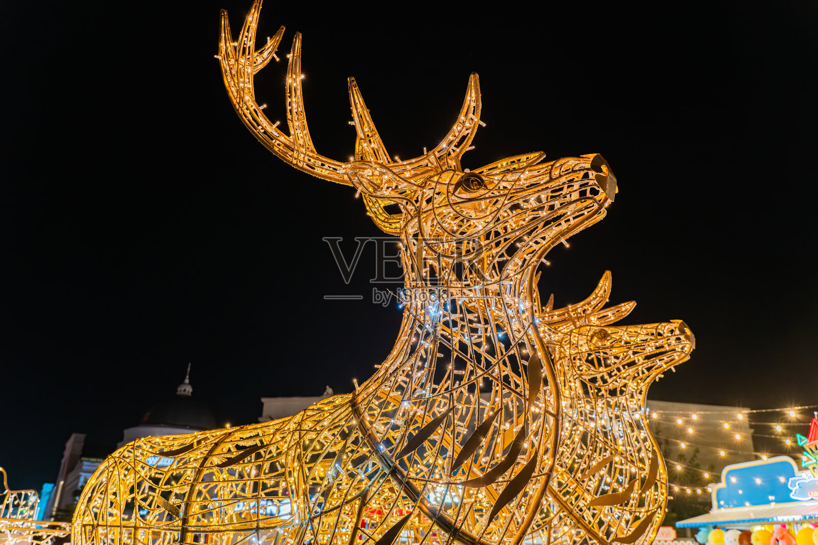 街道装饰着发光的圣诞灯，形状像一只鹿照片摄影图片