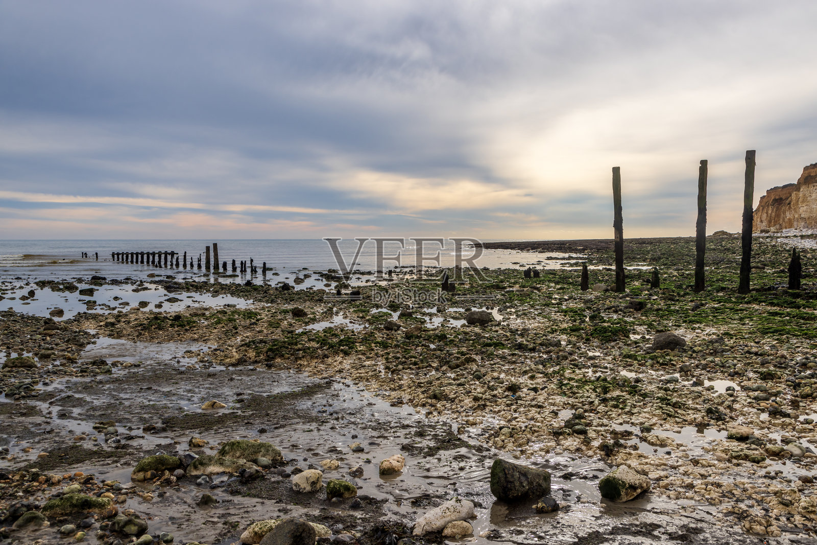 萨塞克斯的库克梅尔港低潮，水中有风化的防波堤照片摄影图片