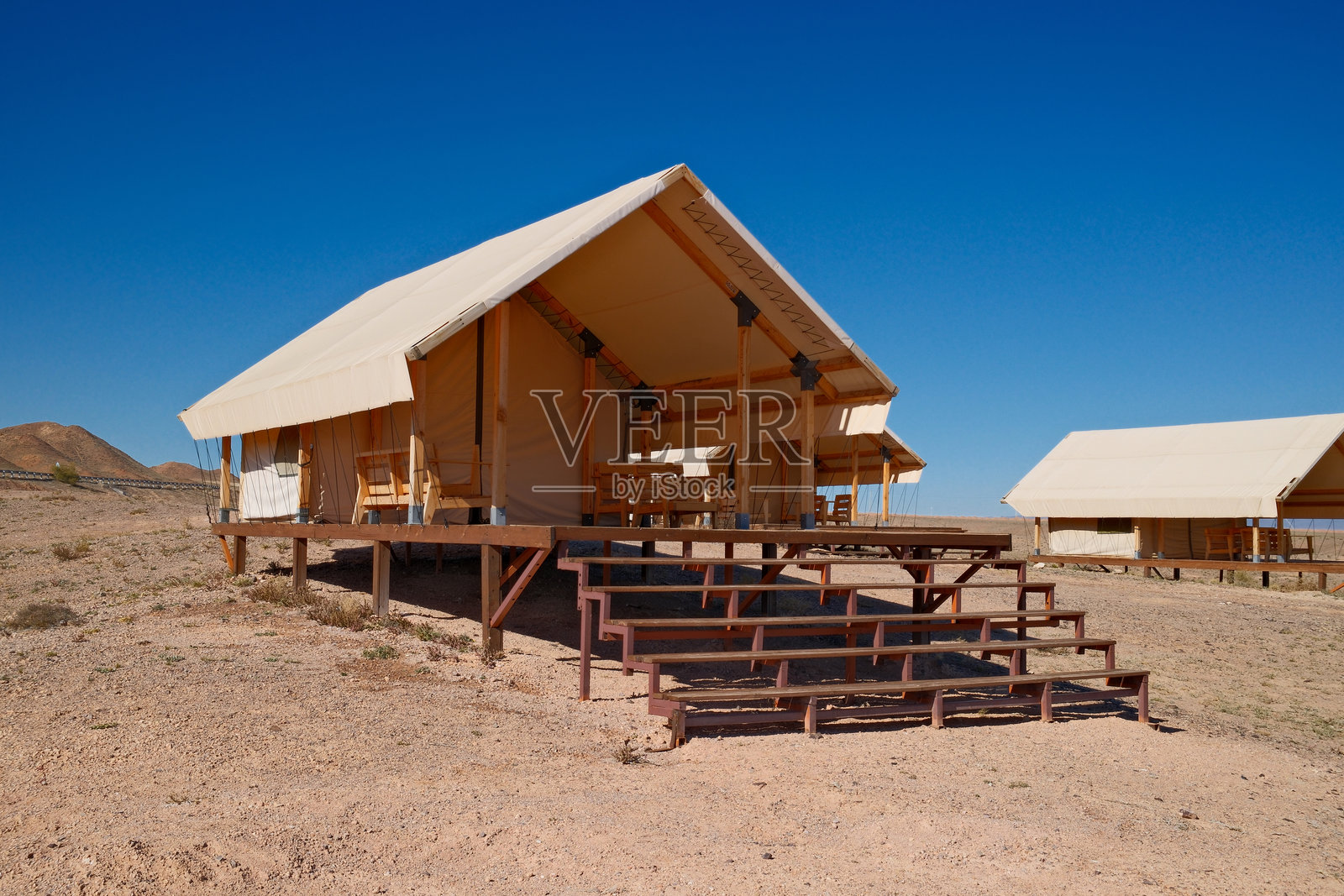 奢华沙漠露营。高档帐篷小屋配有木质甲板照片摄影图片