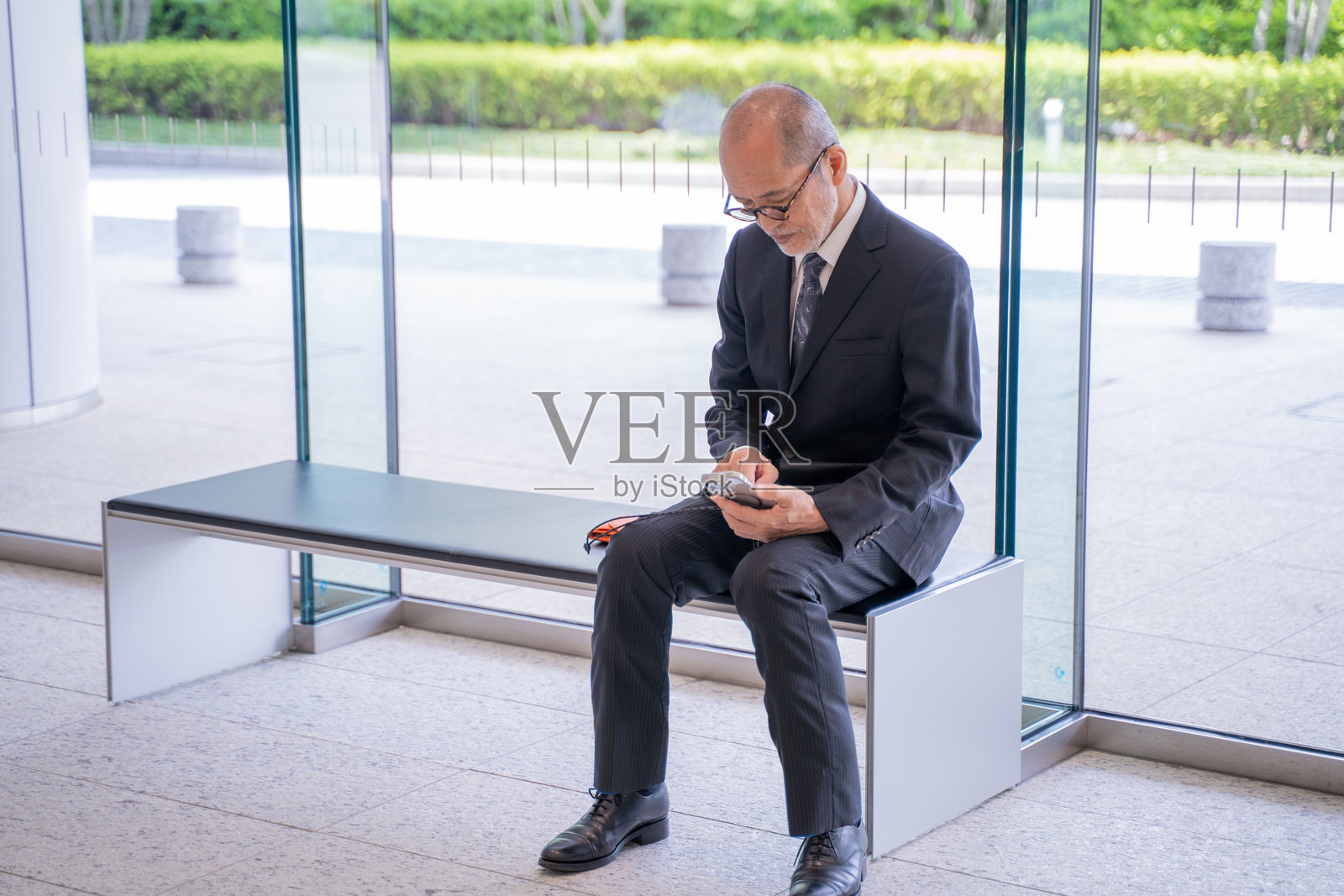 老年男性商人在使用智能手机照片摄影图片