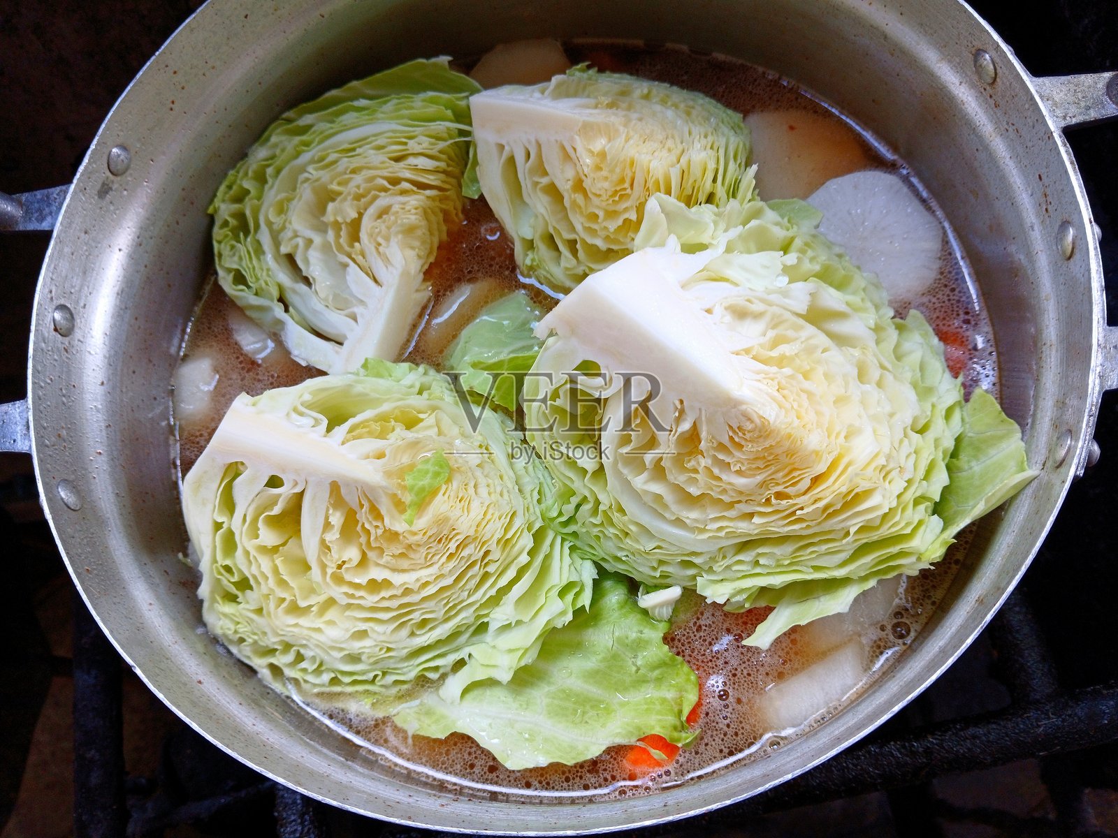 在炉子上煮混合蔬菜炖汤 - 食物准备。照片摄影图片