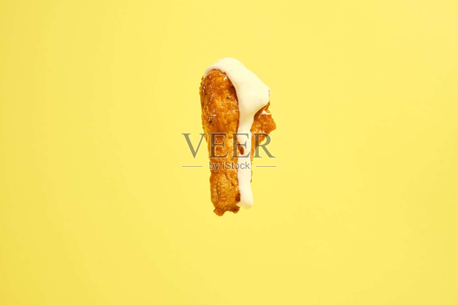 热辣水牛鸡翅腿在黄色背景上与牧场酱一起摆放照片摄影图片