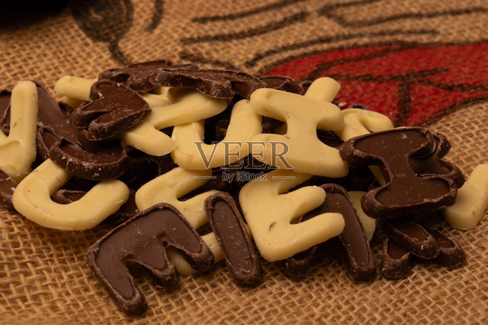 许多小巧的巧克力字母，堆成一堆照片摄影图片