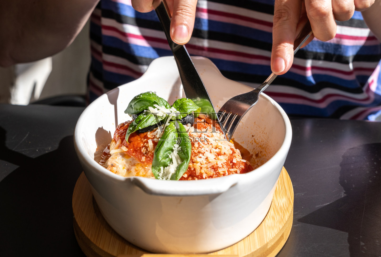 烤制的千层面，层层意大利面配上奶酪、碎肉和番茄，阳光明媚的夏日午后。照片摄影图片