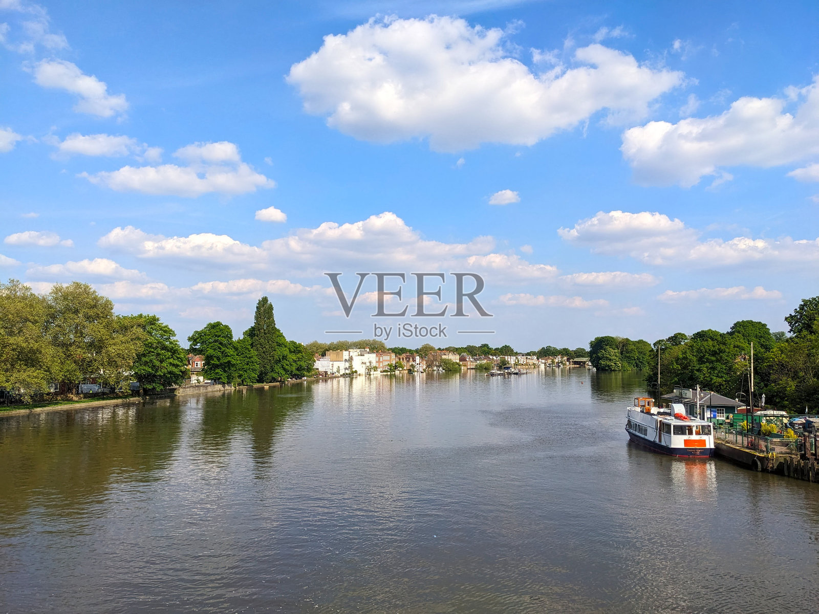 泰晤士河的潮流，右侧停靠着一艘船在基尤码头。照片摄影图片