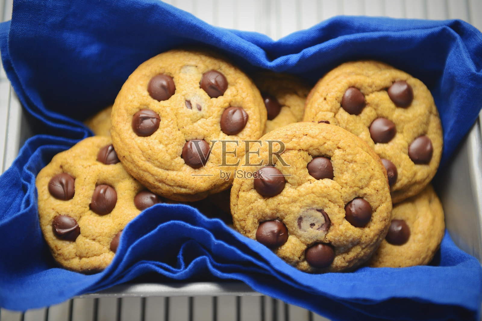 蓝色布料上的巧克力曲奇饼干特写，放在冷却架上照片摄影图片