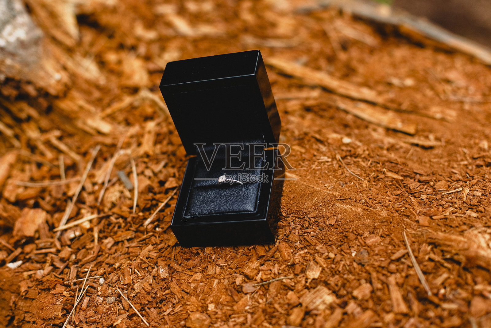 盒子里的戒指特写，放在泥土上照片摄影图片