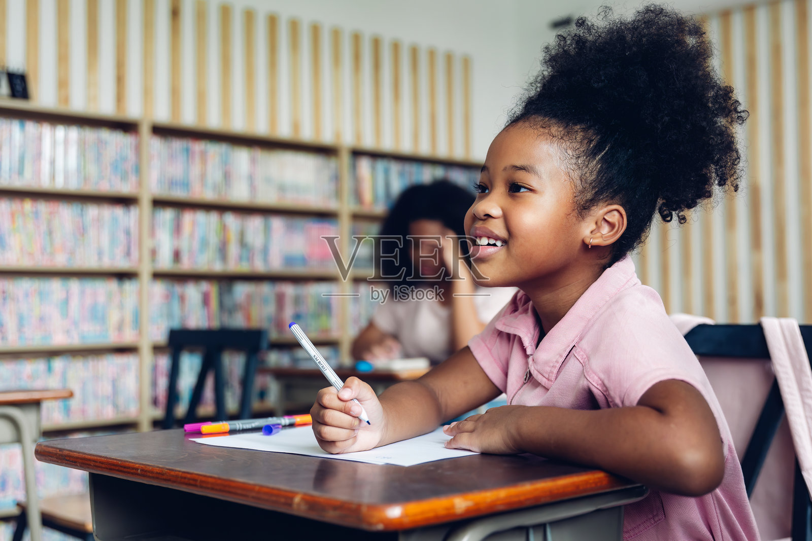 女孩在教室里学习。开学啦！可爱勤奋的孩子们坐在室内的课桌前。孩子们在课堂上学习。照片摄影图片