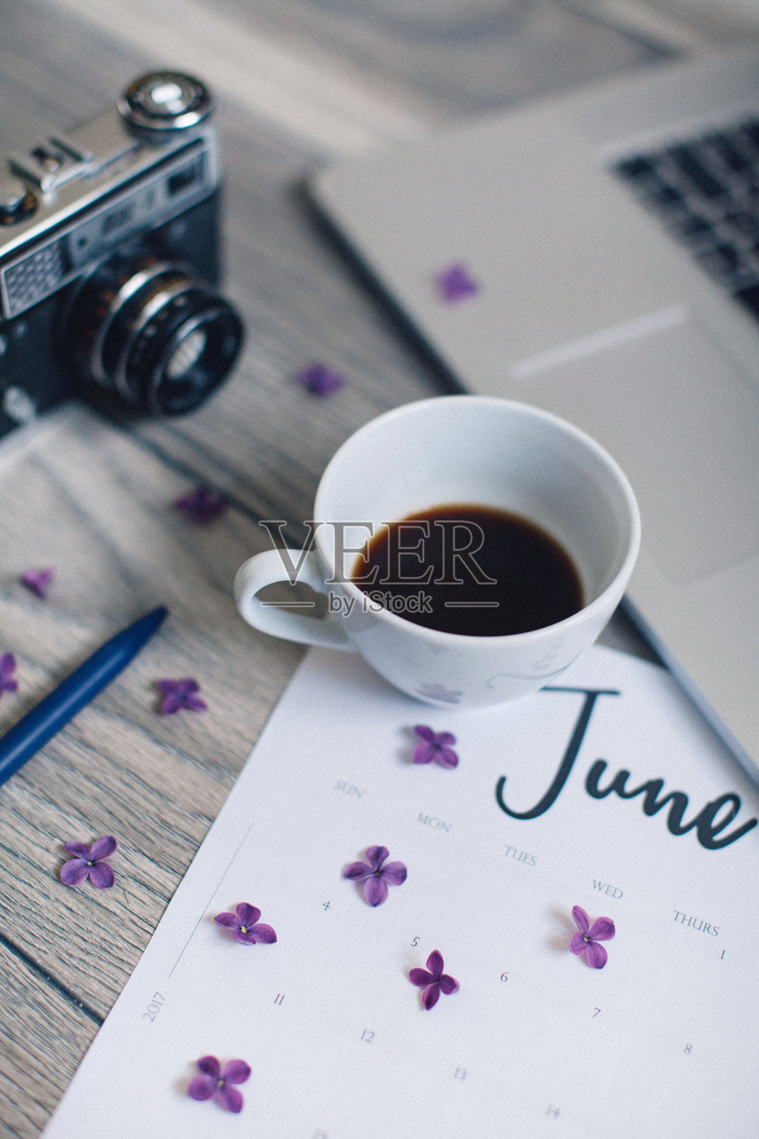 高角度视图的咖啡杯、笔记本电脑和相机放在桌子上照片摄影图片