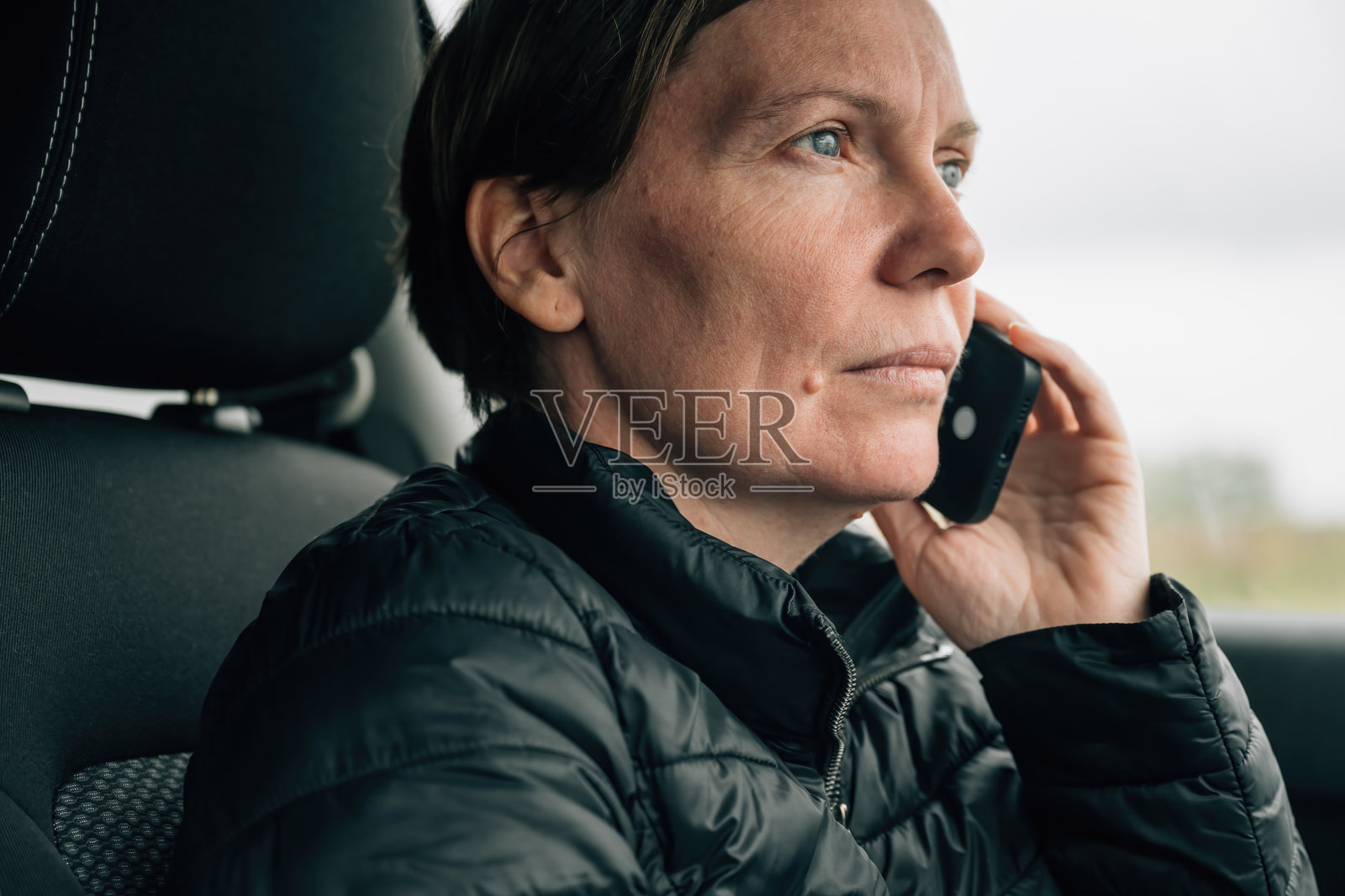 严肃的女性司机在车内打手机照片摄影图片